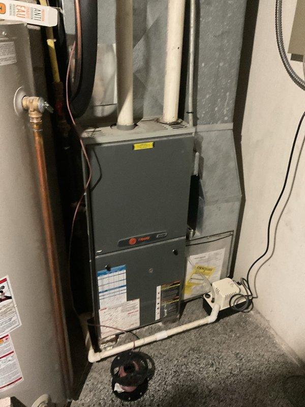 Completed comprehensive estimate for replacement of two furnaces and one air conditioning system. Evaluated existing Trane furnace installation in basement utility room, including ductwork configuration, venting systems, condensate drainage, and electrical connections. Assessed water heater proximity and clearance requirements for proper equipment spacing and code compliance. Photographed current equipment layout, piping arrangements, and mechanical room conditions to develop accurate replacement specifications and installation plan.