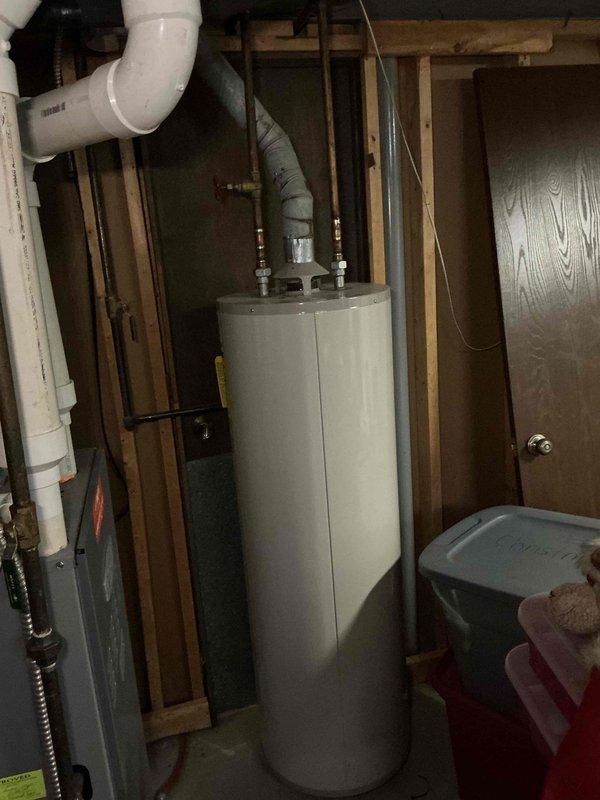 Responded to no cooling complaint on residential air conditioning system. Upon arrival, performed diagnostic inspection of HVAC equipment located in basement utility area. System evaluation completed, findings documented with photographic evidence of furnace unit and associated mechanical equipment including water heater and ventilation components in unfinished basement space.