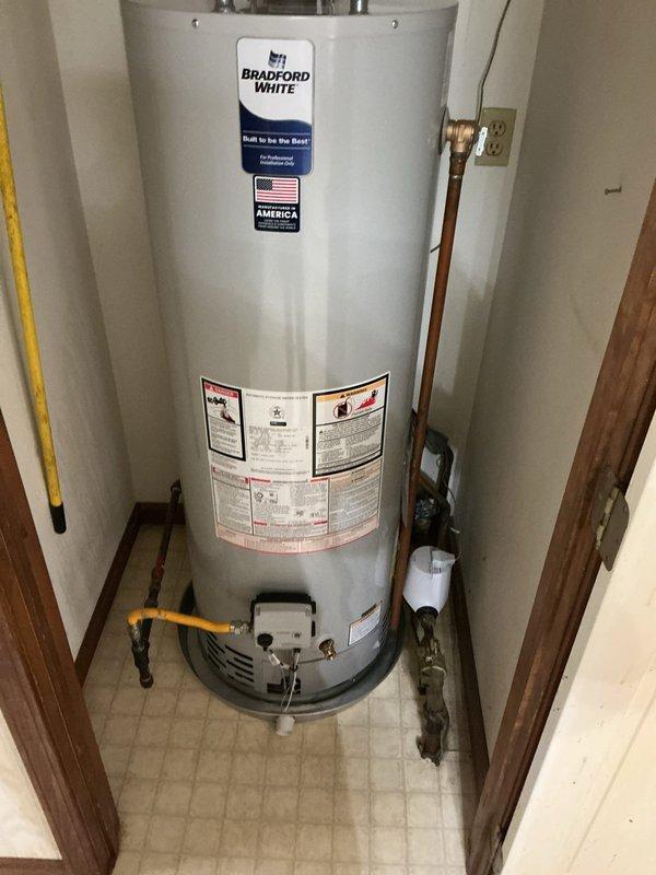 Responded to warranty callback for newly installed Bradford White water heater experiencing active leak. Upon inspection, identified leak source at top connections where copper supply lines interface with unit. Tightened brass fittings on both hot and cold water connections and verified all pipe joints for proper seal. Inspected gas line connection, flue venting, and drain pan placement. Tested system under pressure, confirmed leak resolved, and verified proper hot water delivery. Unit now operating within manufacturer specifications.