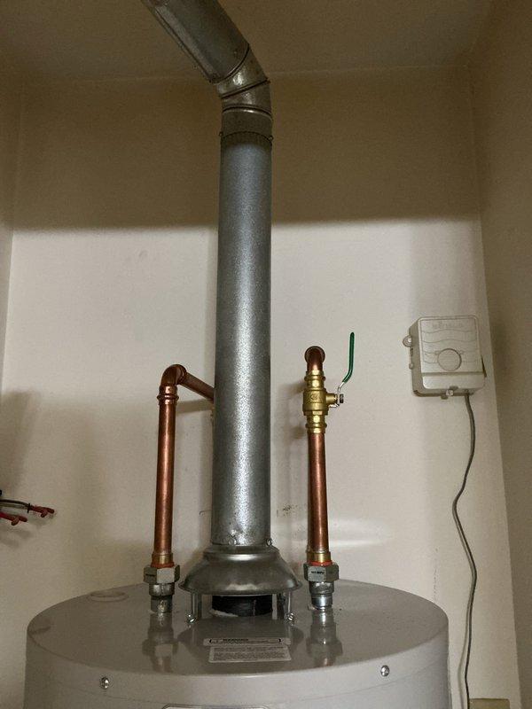 Responded to warranty callback for newly installed Bradford White water heater experiencing active leak. Upon inspection, identified leak source at top connections where copper supply lines interface with unit. Tightened brass fittings on both hot and cold water connections and verified all pipe joints for proper seal. Inspected gas line connection, flue venting, and drain pan placement. Tested system under pressure, confirmed leak resolved, and verified proper hot water delivery. Unit now operating within manufacturer specifications.