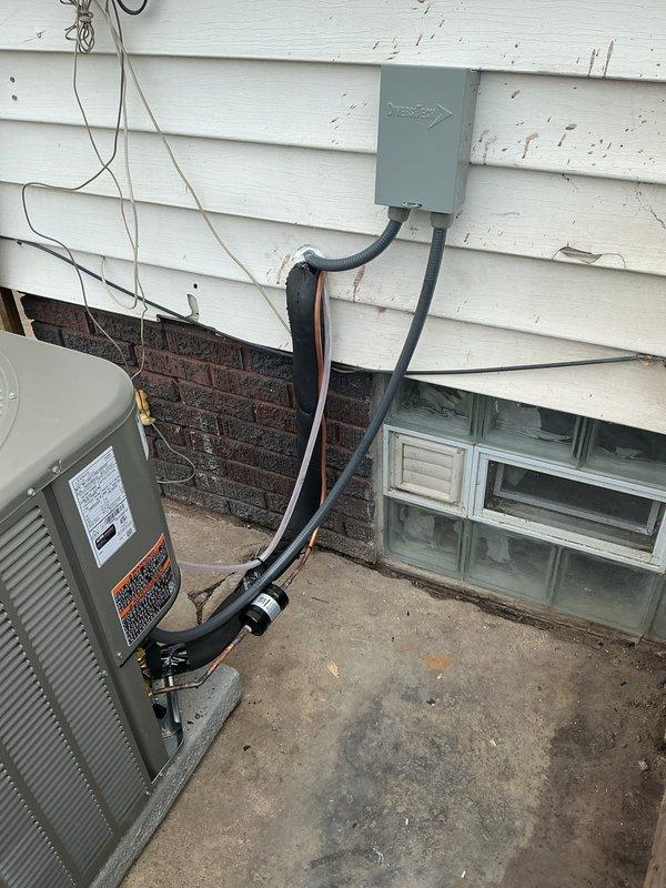Completed installation of single-stage air conditioning system with upflow cased coil package at residential property. Installed new outdoor condensing unit on concrete pad with electrical disconnect and whip, utilizing abandoned dryer circuit for power supply. Added junction box with 20 feet of #10 AWG wiring to connect to existing 30-amp circuit. Ran new 3/4-inch metal line set 25 feet from outdoor unit to indoor coil installation. Mounted new evaporator coil to existing Amana air handler in basement mechanical room. Secured refrigerant lines and electrical conduit to exterior wall per code requirements. Reused existing thermostat for system control. Tested all electrical connections, verified proper voltage at disconnect, and confirmed system startup and operation.