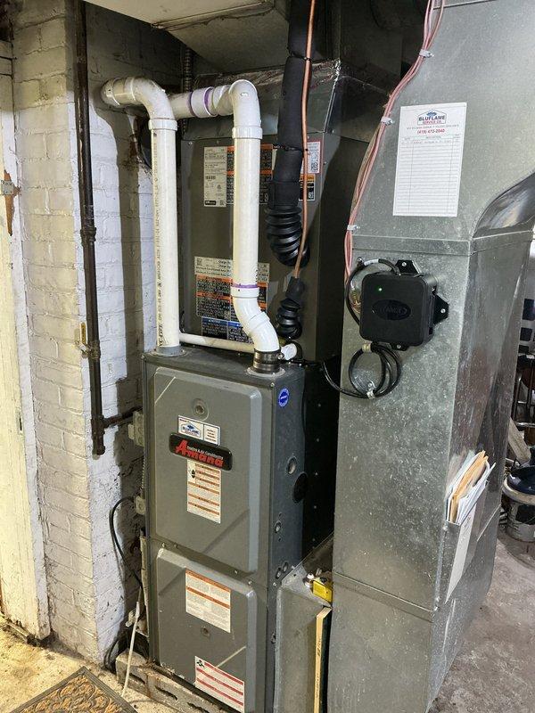 Completed installation of single-stage air conditioning system with upflow cased coil package at residential property. Installed new outdoor condensing unit on concrete pad with electrical disconnect and whip, utilizing abandoned dryer circuit for power supply. Added junction box with 20 feet of #10 AWG wiring to connect to existing 30-amp circuit. Ran new 3/4-inch metal line set 25 feet from outdoor unit to indoor coil installation. Mounted new evaporator coil to existing Amana air handler in basement mechanical room. Secured refrigerant lines and electrical conduit to exterior wall per code requirements. Reused existing thermostat for system control. Tested all electrical connections, verified proper voltage at disconnect, and confirmed system startup and operation.