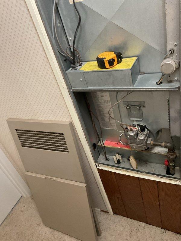 Completed comprehensive assessment of existing HVAC system for full replacement estimate. Evaluated outdoor condenser unit showing signs of age and weathering, positioned on deteriorated concrete pad with visible cracking and vegetation growth. Unit displayed functional operation but exhibited wear consistent with extended service life. Documented electrical disconnect and reviewed exterior installation conditions including clearances and mounting surface integrity.

Inspected indoor furnace system with access panel removed to assess internal components and compatibility requirements for new equipment. Examined gas burner assembly, control wiring, gas valve connections, and pilot light operation. Verified existing ductwork connections, return air configuration, and available installation space for replacement equipment. Measured clearances and documented current system specifications to ensure proper sizing and compatibility of proposed replacement unit. Photographed both indoor and ou