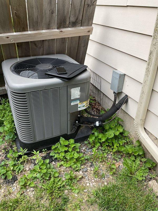 Conducted comprehensive assessment of existing residential HVAC system for complete air conditioning replacement. Evaluated outdoor Lennox condenser unit positioned on gravel pad against house exterior, noting current refrigerant line routing and electrical connections. Inspected indoor basement equipment including existing Lennox furnace and associated ductwork configuration. Documented equipment specifications, system layout, and installation parameters. Provided detailed estimate for new AC system installation including outdoor condenser unit, refrigerant line set, electrical requirements, and integration with existing forced-air heating system.