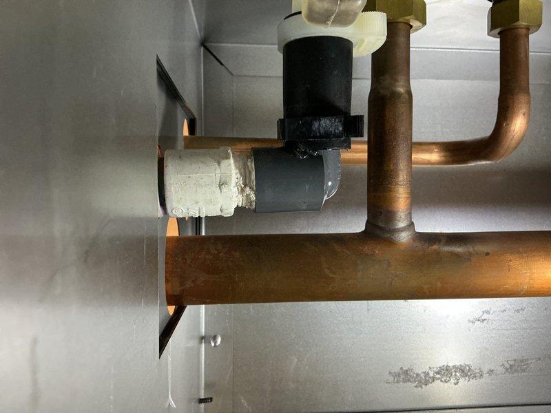 Responded to service call for gas boiler leak at circulation pump connection and within boiler cabinet. Upon inspection, identified active water leak at the pump-to-piping connection point where the circulator interfaces with the brass fittings. Documented existing conditions showing corrosion and patina on brass components and aging flexible connector at pump discharge. Tightened connection points at circulation pump flange and verified integrity of mounting bolts and gasket seal. Inspected boiler cabinet interior for additional leak sources and confirmed moisture presence. Recommended monitoring system pressure and potential replacement of circulator pump and associated fittings due to age-related deterioration of components.
