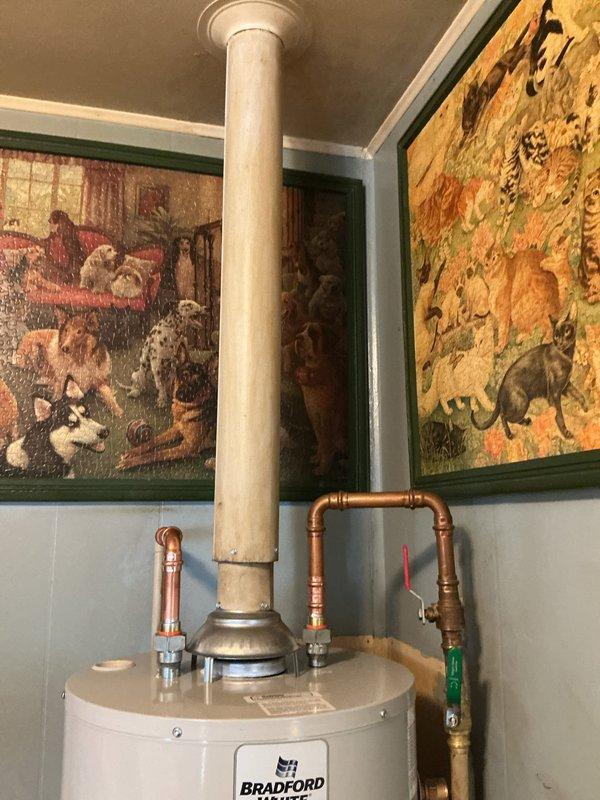 Completed installation of a 40-gallon Bradford White residential water heater in utility area. Connected copper supply and discharge lines with proper shutoff valves, installed exhaust venting system extending to ceiling, and verified all plumbing connections for proper alignment and secure fittings using precision leveling equipment.