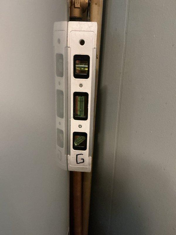 Completed installation of a 40-gallon Bradford White residential water heater in utility area. Connected copper supply and discharge lines with proper shutoff valves, installed exhaust venting system extending to ceiling, and verified all plumbing connections for proper alignment and secure fittings using precision leveling equipment.