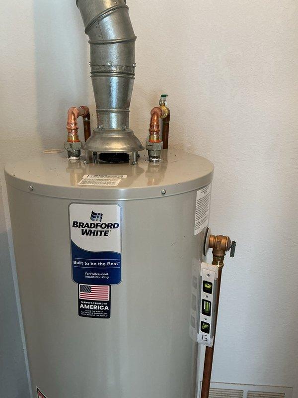 Completed installation of a Bradford White automatic storage natural gas water heater with 151.4-liter (approximately 40-gallon) capacity. Connected copper supply lines to hot and cold water inlets, installed temperature and pressure relief valve with discharge piping, and secured galvanized vent flue for proper exhaust ventilation. Verified all gas connections, tested unit operation, and confirmed compliance with manufacturer's clearance specifications and safety requirements.