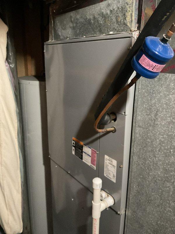 Conducted comprehensive assessment of existing HVAC system for complete replacement estimate. Evaluated indoor air handler unit located in basement utility area, noting aged copper refrigerant lines with oxidation, filter drier component, and PVC condensate drainage system. Inspected outdoor condensing unit positioned on concrete pad with electrical disconnect, documenting current equipment specifications and installation configuration. Photographed both components to provide detailed documentation of existing system condition for replacement proposal.