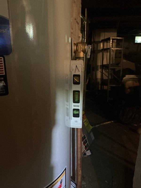 Replaced existing 40-gallon standard atmospheric vent water heater with new Bradford White unit in basement location. Installation included proper leveling of unit on concrete floor, connection of copper supply lines with brass fittings and compression joints, and attachment to existing gray metal vent piping for exhaust ventilation. Verified unit was plumb and level to manufacturer specifications to ensure proper operation and longevity of the appliance.