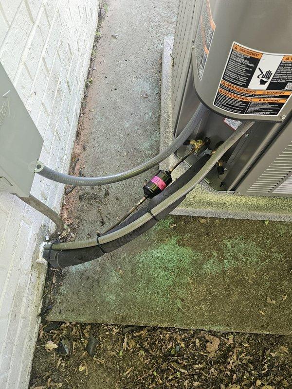 Completed installation of a 3.5-ton single-stage air conditioning system with matching evaporator coil at residential property. Removed existing equipment and installed new outdoor condenser unit on freshly poured concrete equipment pad positioned against exterior wall. Mounted new electrical disconnect box on wall adjacent to condenser for code-compliant service access. Flushed and pressure-tested refrigerant line set to ensure system integrity and proper oil circulation. Installed new evaporator coil in air handler, verifying proper fitment and drain line connections. Ran new refrigerant lines between indoor and outdoor units, insulating suction line to prevent condensation. Evacuated system to 500 microns and charged with manufacturer-specified refrigerant to nameplate specifications. Installed new programmable thermostat, wiring to air handler and configuring for single-stage cooling operation. Verified all electrical connections meet NEC requirements and tested system startup sequ
