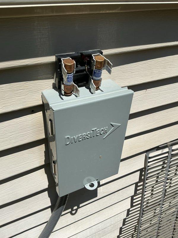 Completed routine maintenance on 2-year-old air conditioning system. Inspected electrical disconnect box with fuses, verified proper operation of capacitor connections, and checked refrigerant lines for secure installation. All components found in good working condition with no issues requiring repair.