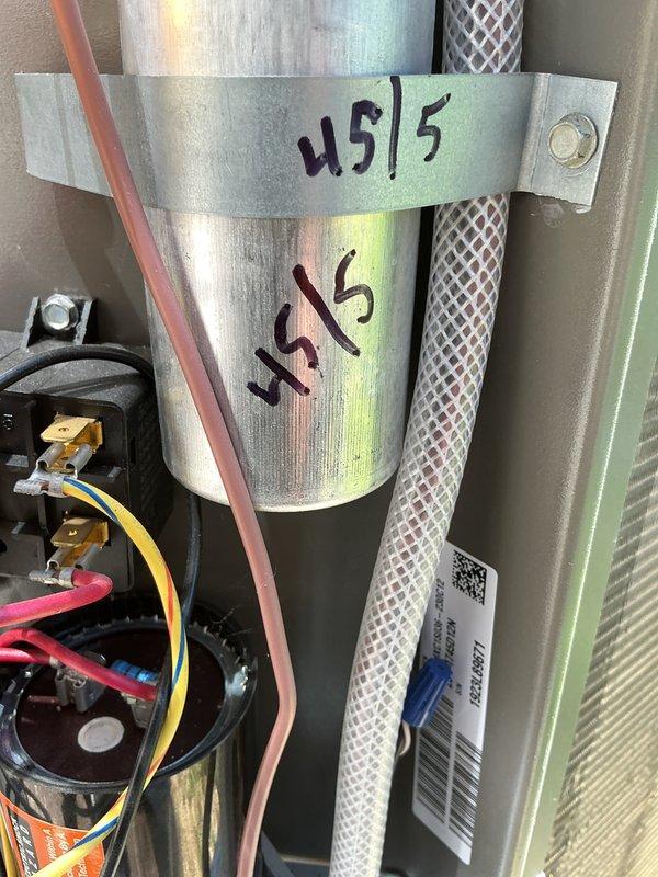 Completed routine maintenance on 2-year-old air conditioning system. Inspected electrical disconnect box with fuses, verified proper operation of capacitor connections, and checked refrigerant lines for secure installation. All components found in good working condition with no issues requiring repair.