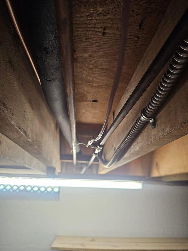 Completed installation of new air conditioning system with upflow cased coil package in basement location. Installed 3/4" x 30' refrigerant line set with proper insulation, routed through floor joists and secured with appropriate mounting hardware. Set new outdoor condensing unit on concrete pad with required disconnect and whip for electrical connection. Mounted upflow coil in existing ductwork with new 16x25x5 metal filter rack for proper filtration. Installed programmable thermostat for enhanced temperature control and energy efficiency. Evacuated refrigerant lines to manufacturer specifications, charged system to proper levels, and verified all electrical connections meet code requirements. Tested system operation through complete cooling cycle, confirmed proper airflow, temperature split, and thermostat functionality. All components operating within normal parameters and system ready for service.