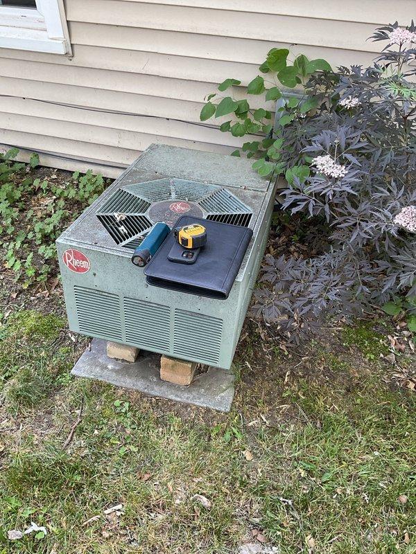 Conducted comprehensive assessment of existing HVAC system for replacement estimate. Evaluated indoor furnace and air handler unit located in utility closet, noting current vertical configuration and space constraints. Inspected outdoor Rheem condenser unit on concrete pad, documenting equipment age, condition, and installation setup. Photographed both indoor and outdoor components to provide detailed documentation for replacement equipment specifications and installation planning.