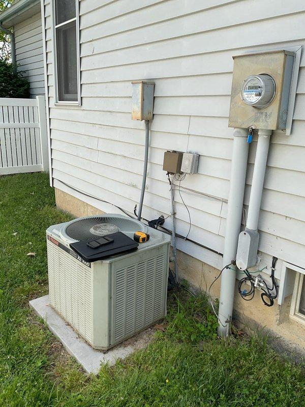 Conducted comprehensive assessment of existing HVAC system for complete replacement estimate. Evaluated outdoor air conditioning condenser unit positioned on concrete pad at ground level, documenting current equipment condition, electrical connections, and clearance requirements. Inspected indoor furnace unit located in basement utility area, noting existing ductwork configuration, PVC drainage piping, and available space for new equipment installation. Photographed electrical service connections including meter housing and conduit routing to determine compatibility with replacement system specifications. Provided detailed estimate for complete AC system replacement including removal of existing equipment and installation of new high-efficiency unit.