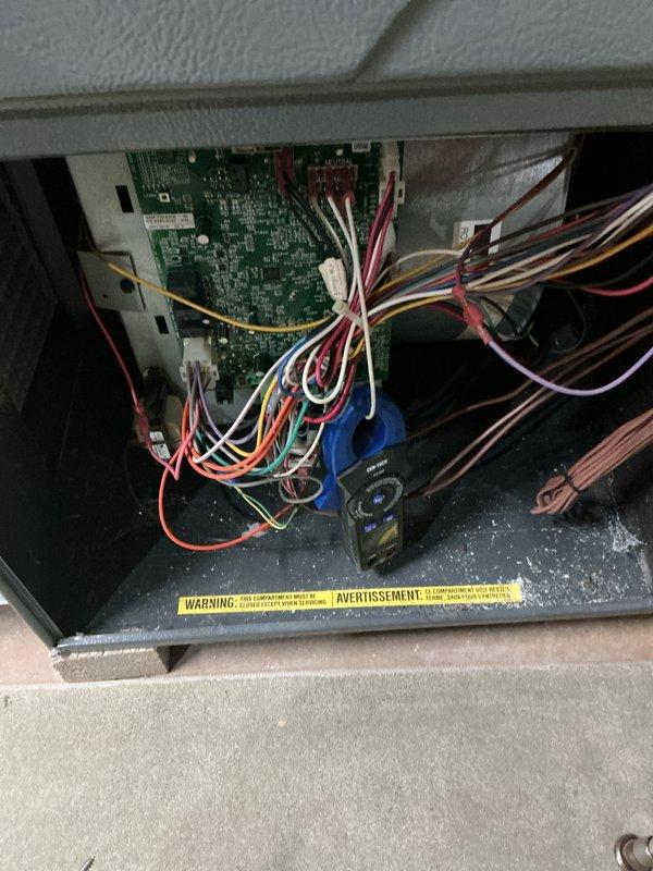 Completed comprehensive cooling maintenance on 13-year-old air conditioning system. Performed electrical diagnostics using clamp meter, recording amperage readings of 5.72 amps at the outdoor unit's electrical connection panel. Inspected control board and wiring connections inside equipment compartment, verifying proper operation of all electrical components and wire terminations across multiple circuits including power, control, and communication wiring.