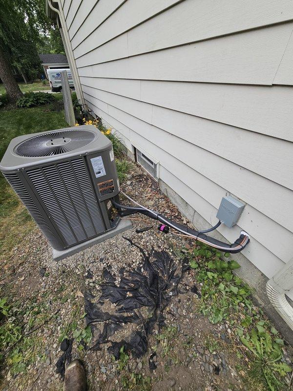 Completed installation of 13 SEER air conditioning system with matched upflow cased coil, B-width configuration. Installed new 3/4" x 30' refrigerant line set with proper insulation, routed along exterior foundation to outdoor condensing unit. Set new equipment pad with gravel base for proper drainage and unit stability. Mounted new electrical disconnect box on exterior siding and installed whip connection to condensing unit per code requirements. Installed new thermostat for system control. All refrigerant lines properly secured and insulated, electrical connections completed and verified, system tested for proper operation and cooling performance.