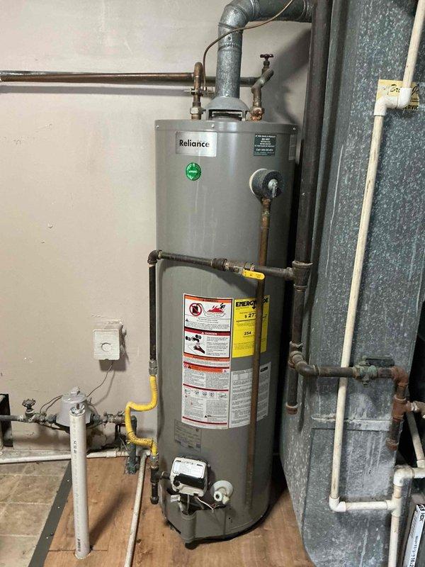 Responded to no cooling call on 25+ year old air conditioning system. Upon arrival, conducted diagnostic inspection of HVAC equipment. Documentation photos captured water heater and associated plumbing components in mechanical room, showing aged copper piping, corrosion buildup, and galvanized ductwork, though primary service focus was air conditioning system evaluation for the non-functional cooling unit.