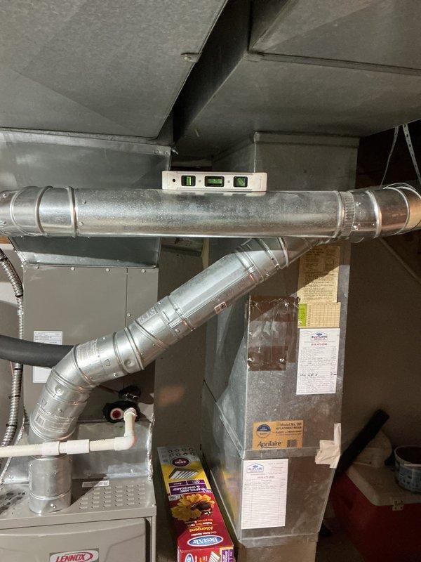 Responded to installation callback to address venting code compliance issues. Corrected hot water tank vent configuration to enter chimney higher than furnace vent per code requirements and adjusted pitch on water heater venting that had been altered during original furnace installation. Verified proper slope using level to ensure condensate drainage. Installed surge protector for equipment protection and provided thermostat programming assistance to ensure proper system operation.