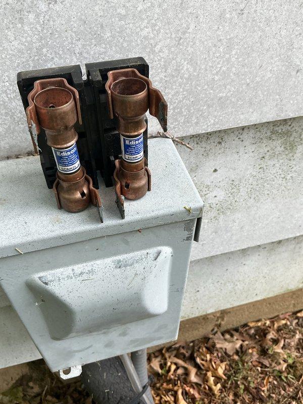 Completed seasonal air conditioning maintenance on 12-15 year old system. Inspected and photographed electrical disconnect box with fuse assembly, verified proper fuse operation and connections. Accessed condensing unit, inspected Emerson control module, capacitor (PRCHD455A rated 440VAC/370VAC), and associated wiring connections; all components found operational with normal wear for unit age.