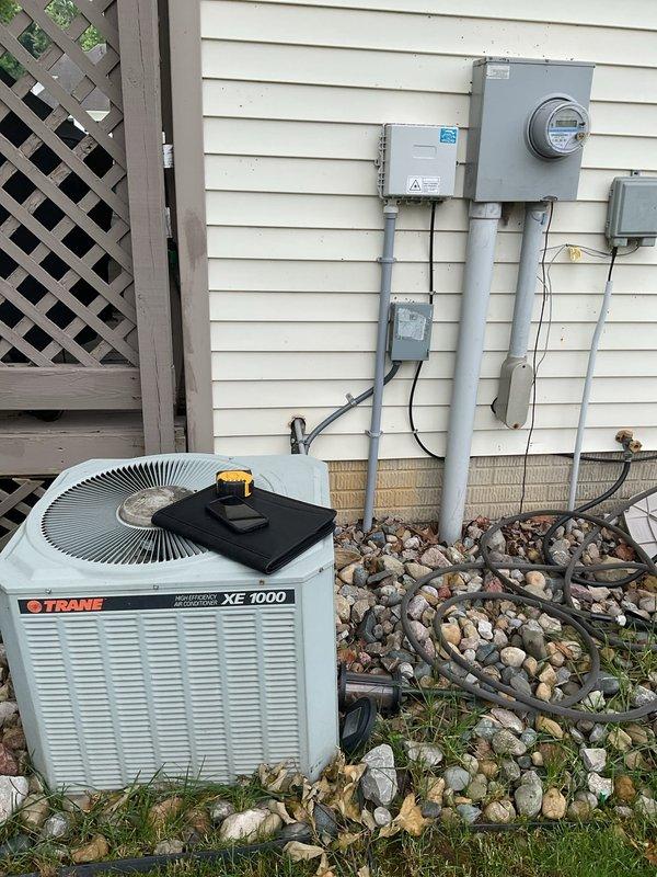 Conducted comprehensive evaluation of existing HVAC system for complete replacement estimate. Assessed current Trane XE 1000 outdoor condensing unit and indoor furnace system located in basement utility area. Documented existing equipment configuration, including ductwork installation, electrical service connections, and system positioning. Photographed indoor air handler with existing ductwork and outdoor condenser unit placement adjacent to electrical meter and disconnect panels. Provided customer with detailed replacement options for complete heating and cooling system upgrade.