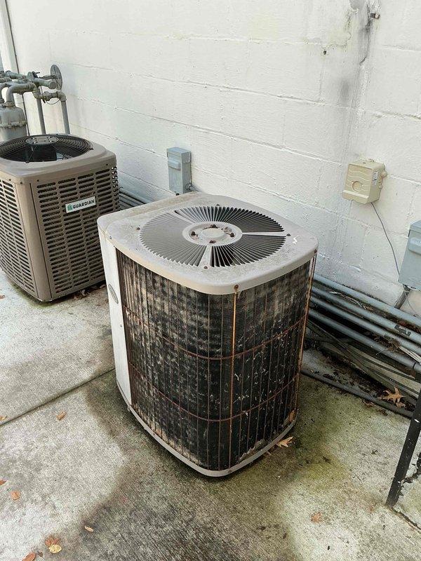 Responded to no cooling complaint on residential air conditioning system. Upon arrival, confirmed outdoor fan motor operation but system failing to produce cool air. Performed diagnostic inspection of outdoor condenser unit, which exhibited significant weathering, dirt accumulation, and rust staining on exterior surfaces. Visual inspection revealed deteriorated insulation on refrigerant line set and general lack of maintenance. System evaluation confirmed customer suspicion of refrigerant loss, likely due to leak in refrigerant circuit. Documented equipment condition with photos showing heavily soiled condenser coil and degraded components requiring attention.