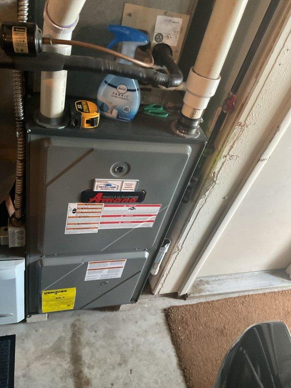 Completed comprehensive estimate for residential air conditioning system replacement. Evaluated existing Amana furnace installation in utility area, assessed current HVAC infrastructure including ductwork, PVC condensate drainage, refrigerant lines, and ventilation components. Documented system configuration and surrounding installation space to provide accurate replacement recommendations and equipment specifications for new AC unit installation.