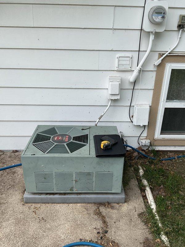 Conducted comprehensive assessment of existing HVAC system and water heating equipment for replacement estimate. Evaluated exterior air conditioning unit showing significant age and weathering, noting older-style condenser with deteriorated cabinet finish and outdated components positioned on concrete pad adjacent to residential structure. Documented existing electrical service configuration including meter location and conduit routing for proper system sizing and electrical requirements.

Inspected interior equipment including existing Rheem furnace and cylindrical water heater in utility area. Assessed current venting configuration with PVC exhaust system, existing ductwork connections, and plumbing infrastructure including copper supply lines, pressure relief valves, and gas piping. Evaluated space constraints and equipment access for replacement installation planning. Documented all utility connections, clearances, and structural considerations necessary for accurate equipment spec