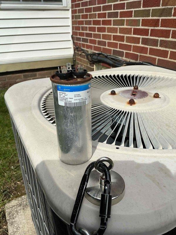 # HVAC Service Report - No Cool Call

Responded to no cooling complaint on 20+ year old residential air conditioning system. Upon arrival, performed diagnostic inspection of outdoor condensing unit. Identified failed dual-run capacitor as primary cause of system failure. Capacitor showed visible signs of weathering, surface corrosion, and electrical degradation typical of age-related component failure. Removed defective capacitor from unit and installed new replacement capacitor with proper microfarad ratings for both compressor and condenser fan motor circuits. Verified all electrical connections at contactor and terminal block were secure and properly torqued. Tested system operation and confirmed compressor and outdoor fan motor both started properly and ran within normal amperage parameters. System restored to full cooling operation.