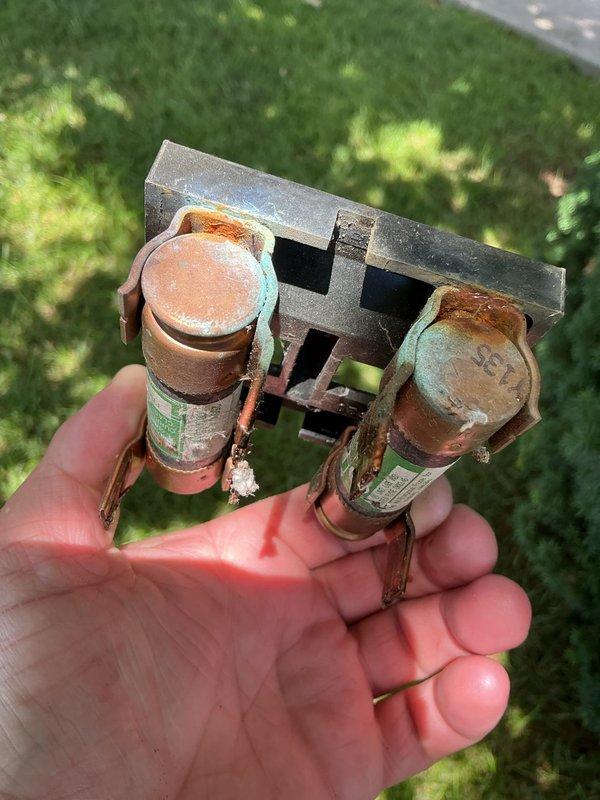 Responded to no cooling complaint on 18-year-old air conditioning system. Upon inspection, found failed dual run capacitor with severe corrosion and oxidation on terminals and housing. Replaced defective capacitor and restored system to proper cooling operation.