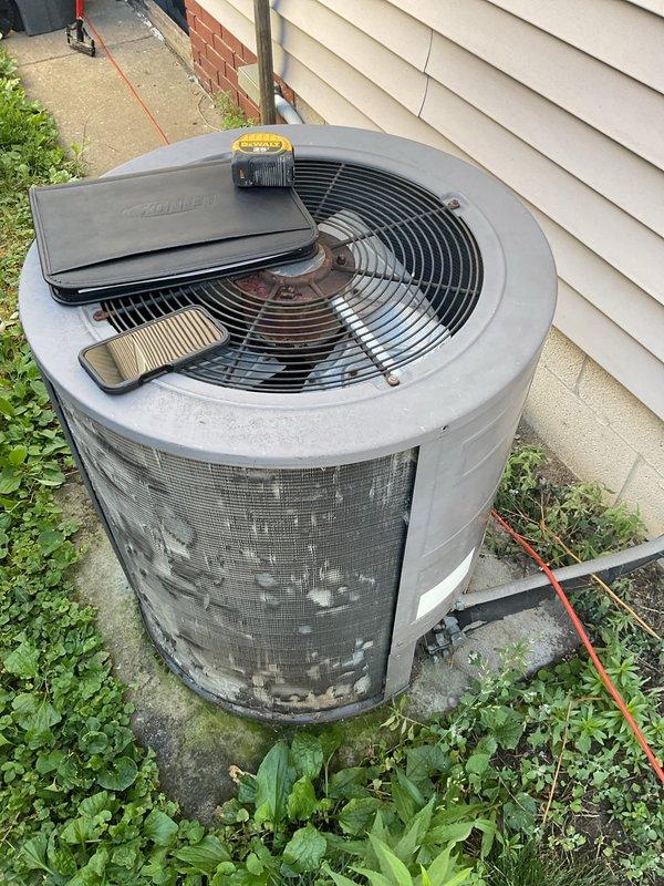 Completed comprehensive evaluation of existing HVAC system for full replacement estimate. Outdoor condensing unit shows extensive rust corrosion and weathering on metal housing and grille panels, indicating advanced age and deterioration requiring replacement. Assessed basement furnace installation, ductwork configuration, and overall system layout to provide accurate replacement specifications and equipment recommendations for complete heating and cooling system upgrade.