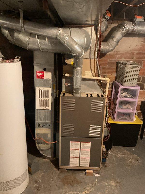 Completed comprehensive evaluation of existing HVAC system for full replacement estimate. Outdoor condensing unit shows extensive rust corrosion and weathering on metal housing and grille panels, indicating advanced age and deterioration requiring replacement. Assessed basement furnace installation, ductwork configuration, and overall system layout to provide accurate replacement specifications and equipment recommendations for complete heating and cooling system upgrade.