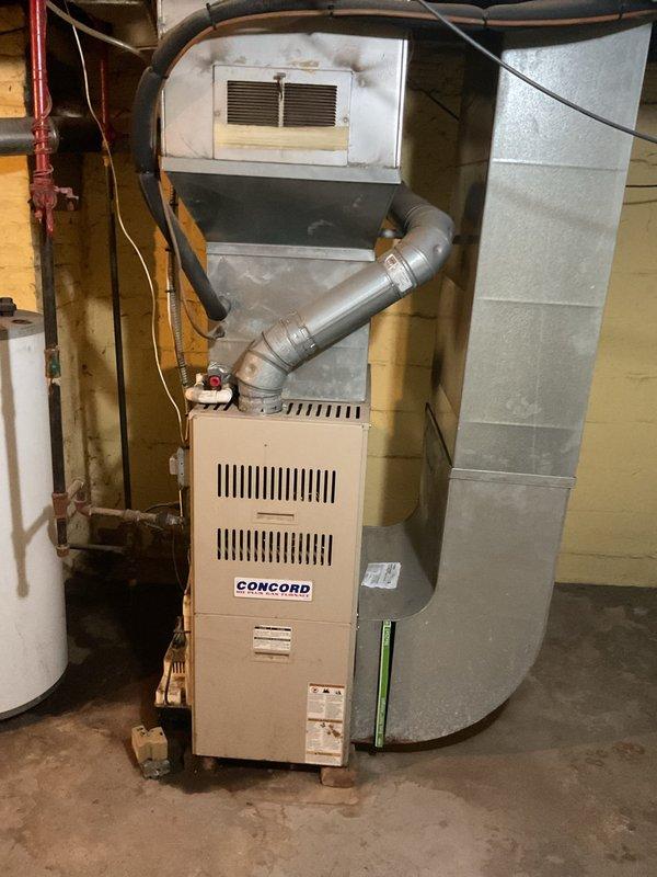 Conducted on-site evaluation for complete HVAC system replacement at residential property. Assessed existing outdoor condensing unit positioned on concrete pad adjacent to building exterior with electrical disconnect box, and indoor Concord furnace installation in basement mechanical room with associated ductwork and ventilation components. Provided comprehensive replacement estimate for new air conditioning system to address customer's cooling needs.