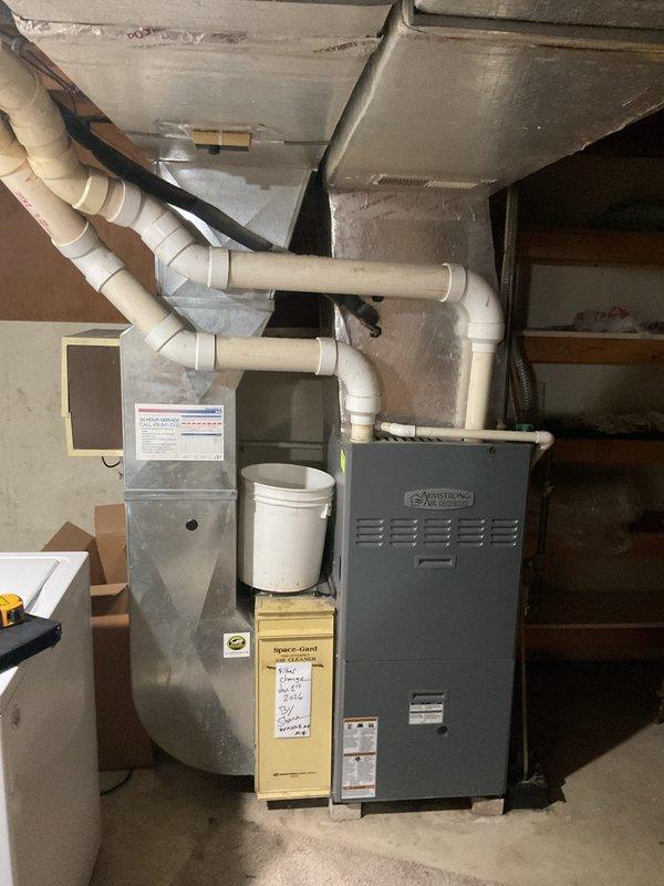 Conducted comprehensive site assessment for complete HVAC system replacement at residential property. Evaluated existing outdoor condenser unit with weathered concrete pad showing signs of age, moss growth, and vegetation encroachment. Inspected indoor furnace and air handler equipment located in basement mechanical room, including existing ductwork configuration, PVC ventilation piping, and current system layout. Documented equipment specifications, spatial constraints, and installation requirements through photographic documentation. Provided detailed replacement estimate covering removal of aging HVAC components and installation of new high-efficiency heating and cooling system.