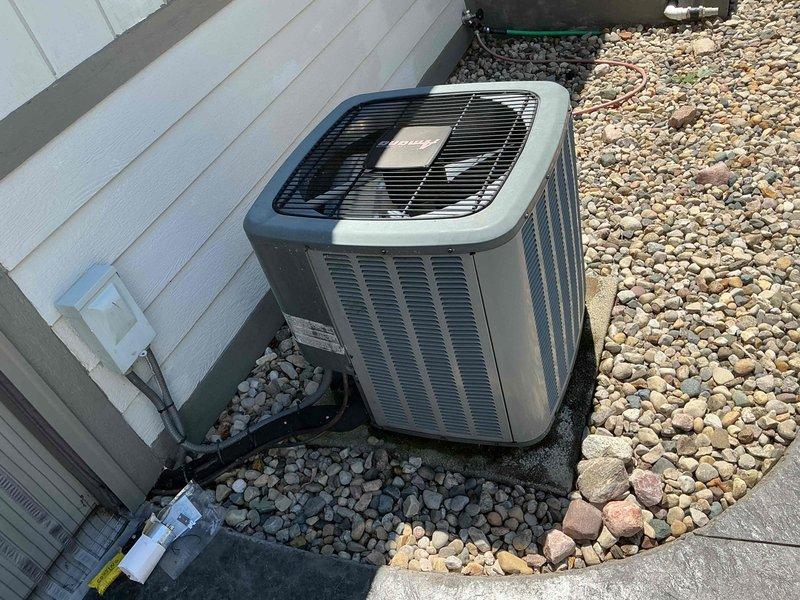 Responded to no cooling complaint on 10-year-old residential air conditioning system. Upon arrival, verified outdoor condenser unit was running but system was not producing cold air. Removed access panel and inspected electrical components including dual-run capacitor (46/5 MFD) and CoreSense diagnostic module. Diagnosed failed capacitor causing compressor to fail to start properly, resulting in loss of cooling capacity. Replaced defective capacitor with OEM-equivalent part, tested system operation, and confirmed proper amperage draw and cooling performance restored.
