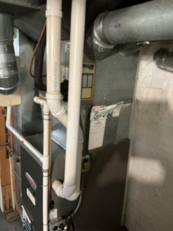 # HVAC Service Call - No Cool/Water Leak

## Primary Complaint
Responded to service call for 21-year-old residential air conditioning system with no cooling capability and active water leak. Unit failing to maintain thermostat setpoint temperature.

## Diagnostic Findings

Upon arrival, performed comprehensive system evaluation. Outdoor condensing unit showed extensive dirt and debris accumulation on condenser coil fins, significantly restricting airflow and reducing heat transfer efficiency. External cabinet displayed weathering consistent with age and lack of preventive maintenance. Vegetation growth around unit further impeding proper ventilation.

Indoor air handler inspection revealed water leak issue originating from condensate drainage system. Observed condensate management components including PVC drain lines and condensate pump assembly. Equipment showing signs of extended service life with original factory labels still intact.

## System Condition Assessment

- Condenser coil