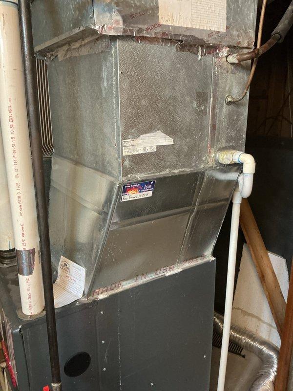 Responded to no cooling complaint with recurring frozen refrigerant line on aging system. Upon arrival, found evaporator coil had previously frozen and thawed. Attached manifold gauges to outdoor condensing unit to check system pressures and diagnose root cause of repeated freeze-ups. System pressures indicated low refrigerant charge, which restricts proper heat exchange and causes ice formation on suction line and evaporator coil. Recommended addressing refrigerant leak and recharge to restore proper cooling operation and prevent continued freeze-up cycles.