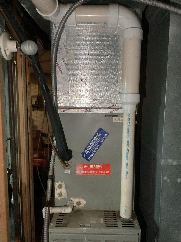 Conducted comprehensive site evaluation for complete HVAC system replacement at residential property. Assessed existing American Standard outdoor condensing unit with associated electrical disconnect and metering equipment mounted on exterior wall. Evaluated indoor air handler system located in basement utility area, including furnace unit with existing ductwork, PVC condensate drainage lines, and electrical connections. Documented current equipment specifications, installation configuration, and all necessary measurements to provide accurate replacement estimate for new AC system installation.