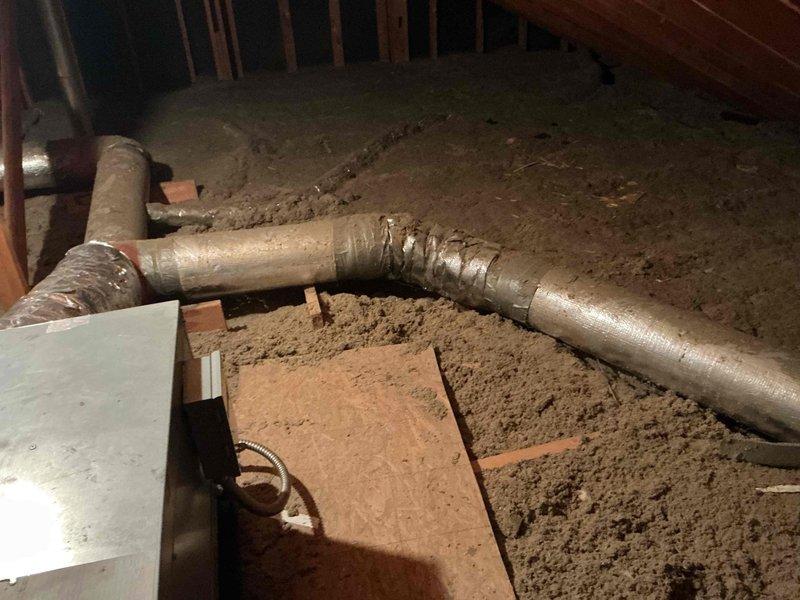 Responded to service call for HVAC system inspection in attic space. Upon arrival, accessed attic and located flexible ductwork system running through insulation. Documented current condition of ductwork installation, noting sections with metallic tape repairs and general routing configuration across loose-fill insulation. Unable to complete full diagnostic assessment as technical support contact was required to proceed with troubleshooting. Will need to return early in day to coordinate with technical support for proper system evaluation and determination of necessary repairs to ductwork system.