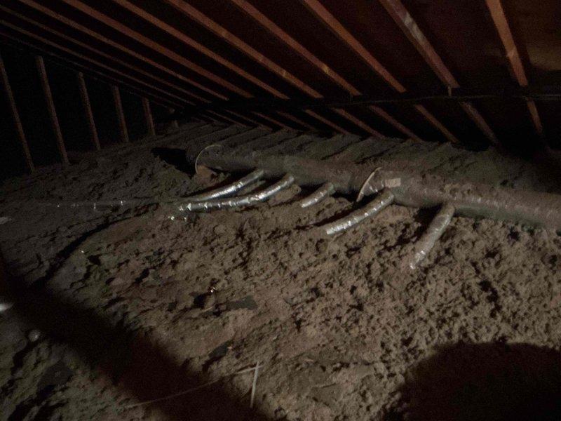 Responded to service call for HVAC system inspection in attic space. Upon arrival, accessed attic and located flexible ductwork system running through insulation. Documented current condition of ductwork installation, noting sections with metallic tape repairs and general routing configuration across loose-fill insulation. Unable to complete full diagnostic assessment as technical support contact was required to proceed with troubleshooting. Will need to return early in day to coordinate with technical support for proper system evaluation and determination of necessary repairs to ductwork system.