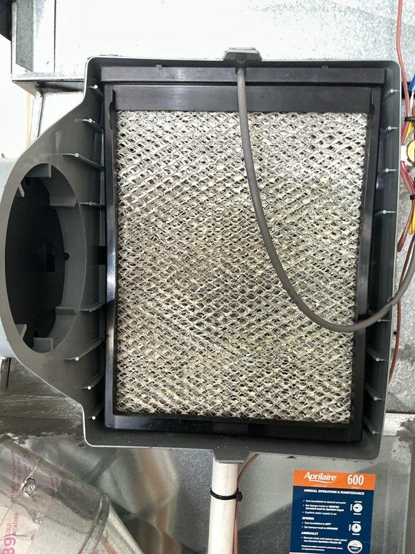 Completed air conditioning tune-up on 3-year-old system and replaced Aprilaire 600M humidifier evaporator pad, which showed mineral buildup and discoloration from normal use. All system components inspected and operating within normal parameters.