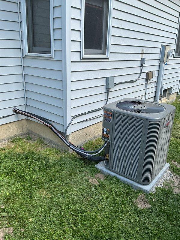 Completed full HVAC system installation including new single-stage air conditioning condenser unit positioned 3 feet from electrical panel on new concrete pad. Installed upflow cased evaporator coil in basement mechanical room with proper refrigerant line connections. Ran new 3/4-inch line set spanning 30 feet from outdoor condenser to indoor coil, with black insulation protecting refrigerant lines throughout the run. Mounted new electrical disconnect box and whip on exterior wall with gray conduit routing to provide proper power supply and service disconnect capability for the condensing unit. Installed new thermostat to provide system control. All components properly connected, tested, and verified operational.