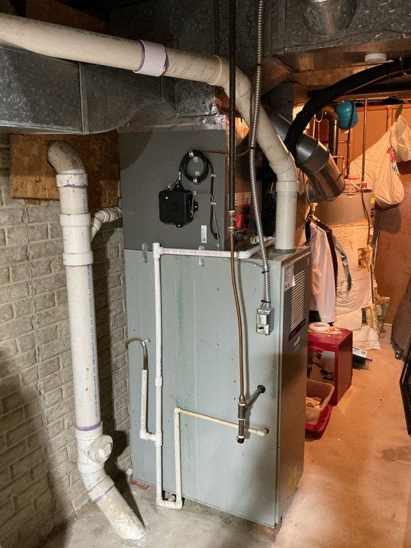 Completed full HVAC system installation including new single-stage air conditioning condenser unit positioned 3 feet from electrical panel on new concrete pad. Installed upflow cased evaporator coil in basement mechanical room with proper refrigerant line connections. Ran new 3/4-inch line set spanning 30 feet from outdoor condenser to indoor coil, with black insulation protecting refrigerant lines throughout the run. Mounted new electrical disconnect box and whip on exterior wall with gray conduit routing to provide proper power supply and service disconnect capability for the condensing unit. Installed new thermostat to provide system control. All components properly connected, tested, and verified operational.