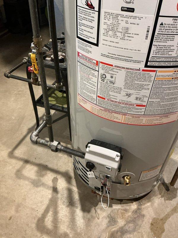 Replaced existing 40-gallon standard water heater in basement utility area. Disconnected old unit, installed new white cylindrical tank water heater with proper plumbing connections including copper piping, brass fittings, yellow-handled shut-off valve, and pressure relief valve assembly. Connected gas control valve assembly at base of unit with appropriate wiring. Verified unit was level and secure on concrete floor. Tested all connections for proper operation and ensured compliance with safety standards.