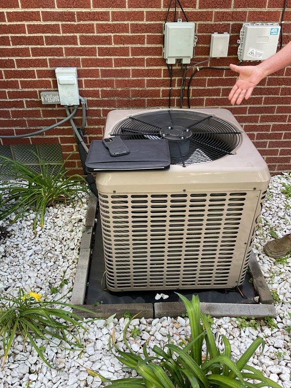 Conducted comprehensive assessment of existing HVAC system for complete replacement estimate. Evaluated outdoor condensing unit installed on platform base against exterior brick wall, documenting current electrical connections, conduit routing, and wall-mounted disconnect components. Inspected indoor air handler installation, examining sheet metal ductwork connections, support framing, refrigerant line routing, and insulation condition. Photographed both outdoor and indoor equipment to document existing system configuration and provide detailed specifications for proposed AC and air handler replacement.