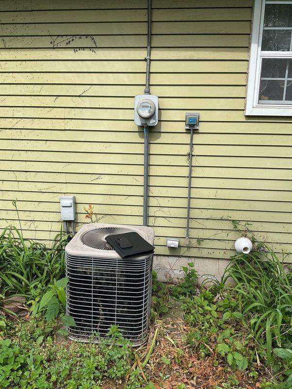 Completed comprehensive assessment of existing HVAC system for replacement estimate. Evaluated outdoor Lennox condenser unit with cylindrical design showing signs of age and weathering, surrounded by overgrown vegetation requiring clearance for proper airflow. Documented indoor Lennox furnace installation in basement mechanical room, including existing ductwork configuration, plenum connections, PVC condensate drainage system, and electrical service requirements. Photographed current system specifications and equipment labels to provide accurate replacement recommendations and ensure proper sizing for new equipment installation.