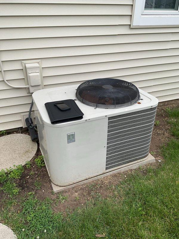 Conducted comprehensive assessment of existing HVAC system for replacement estimate. Evaluated outdoor condensing unit positioned on concrete pad against exterior wall, noting current configuration with top-mounted fan assembly and condenser coil arrangement. Inspected indoor air handler unit located in utility closet, documenting vertical installation with three-section configuration, existing ductwork connections, and condensate drainage system. Photographed equipment specifications, electrical connections, refrigerant line routing, and spatial constraints to provide accurate replacement recommendations for both heating and cooling components.