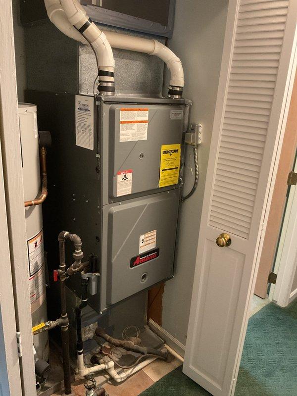 Conducted comprehensive assessment of existing HVAC system for replacement estimate. Evaluated outdoor condensing unit positioned on concrete pad against exterior wall, noting current configuration with top-mounted fan assembly and condenser coil arrangement. Inspected indoor air handler unit located in utility closet, documenting vertical installation with three-section configuration, existing ductwork connections, and condensate drainage system. Photographed equipment specifications, electrical connections, refrigerant line routing, and spatial constraints to provide accurate replacement recommendations for both heating and cooling components.