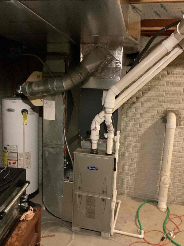 Conducted comprehensive assessment of existing HVAC system for full replacement estimate. Evaluated outdoor Trane XE 1000 condensing unit positioned against home exterior, noting current electrical disconnect configuration and conduit routing up siding. Documented indoor equipment including Carrier furnace, existing ductwork with flexible insulation, and air handler unit in basement utility area. Photographed all major components, electrical connections, and spatial constraints to provide accurate replacement specifications. Customer provided with detailed estimate for complete system replacement including new outdoor condensing unit, indoor air handler, and necessary electrical modifications to meet current code requirements.